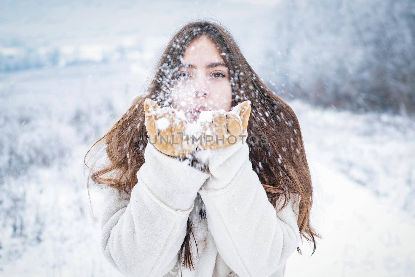 Happy winter girl blow snow. Young woman in winter holidays