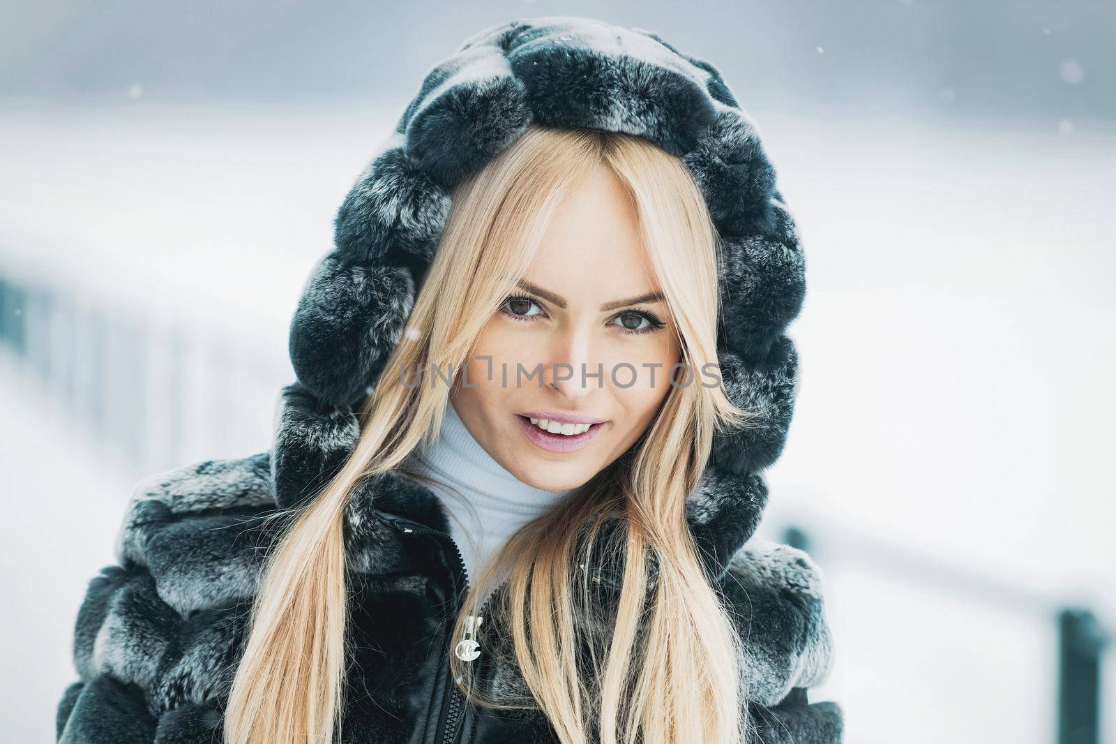 Girl on winter day. Woman Model in fur on snowy nature.