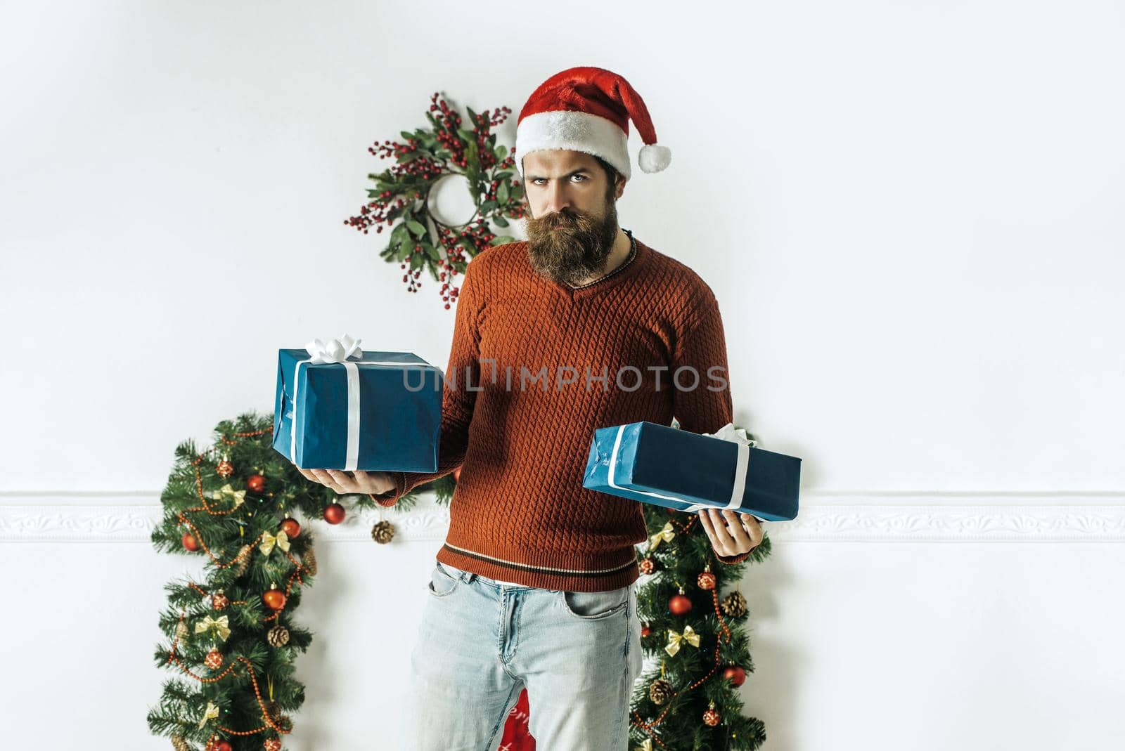 Santa claus man with gift pack. Winter holiday and xmas. Christmas man with beard on serious face at present box.