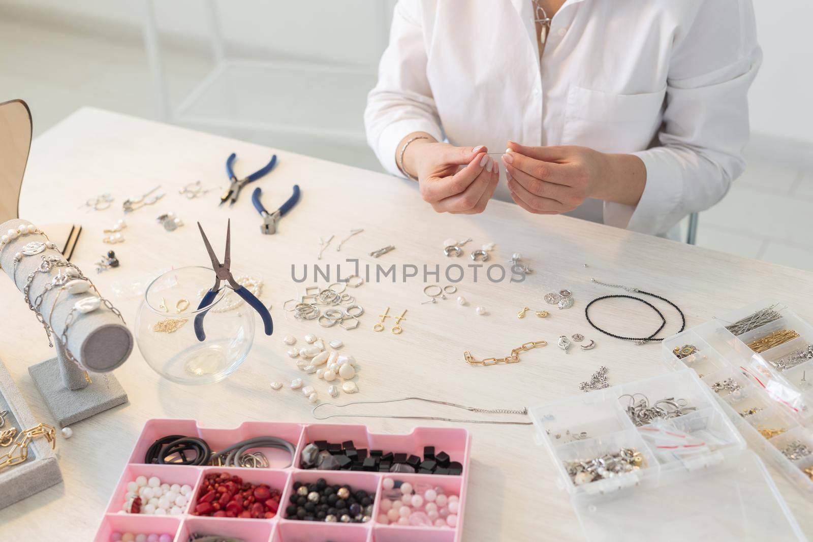 Professional jewelry designer making handmade jewelry in studio workshop. Fashion, creativity and handmade concept.