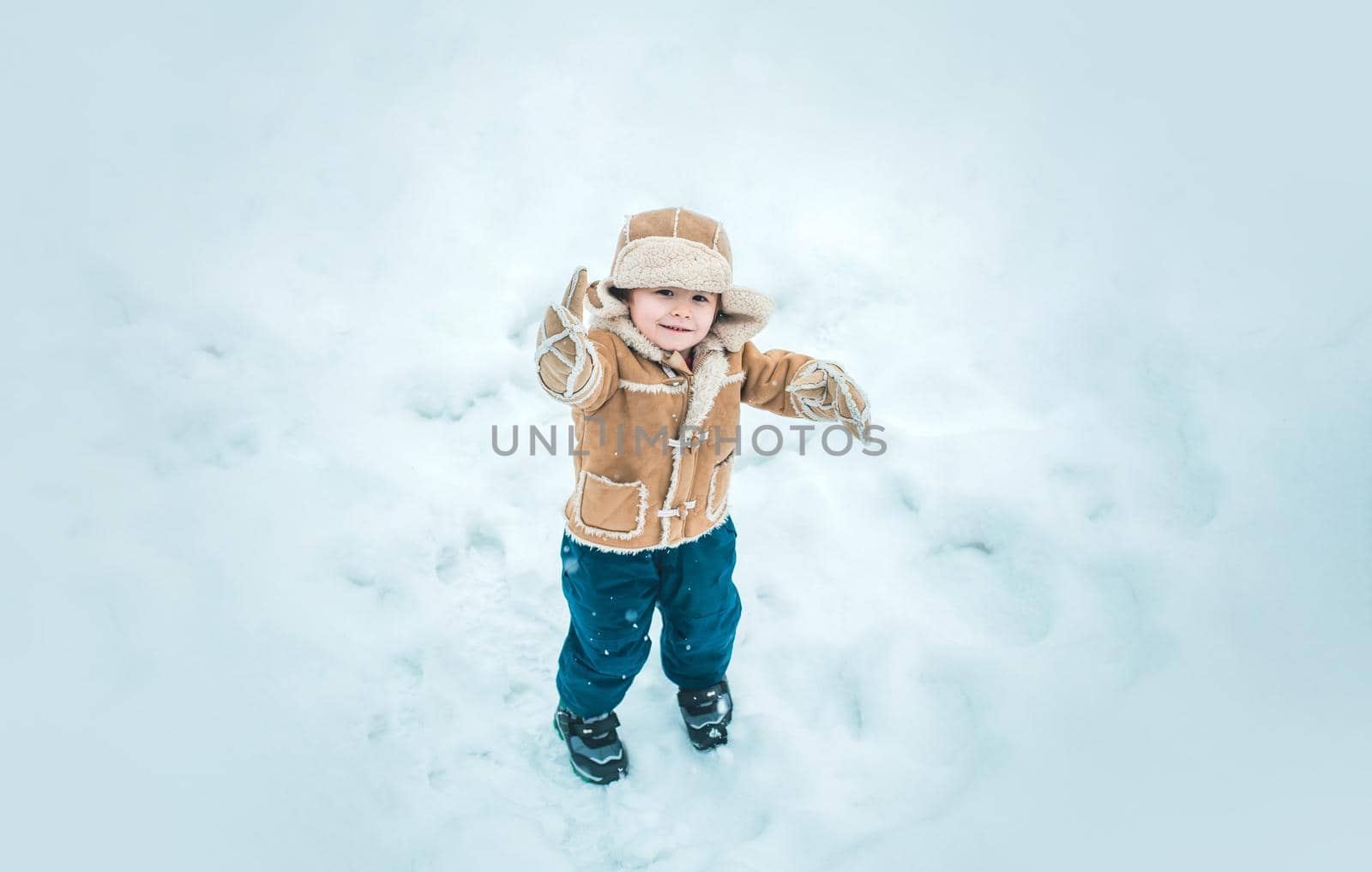 Winter child happy in snow outdoor. Cute boy in winter clothes. Theme Christmas holidays and New Year. by Tverdokhlib