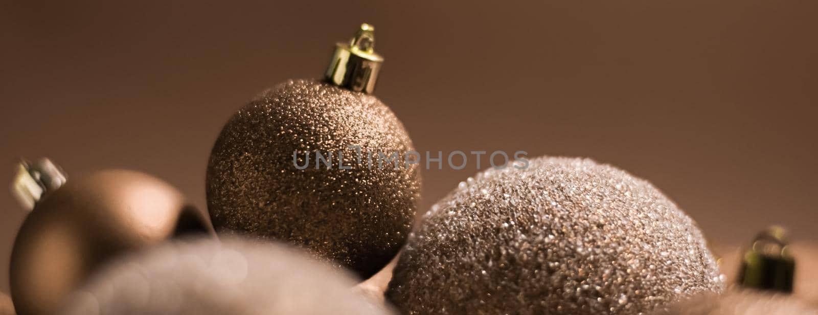 Christmas holiday and festive decoration concept. Golden baubles on beige background.