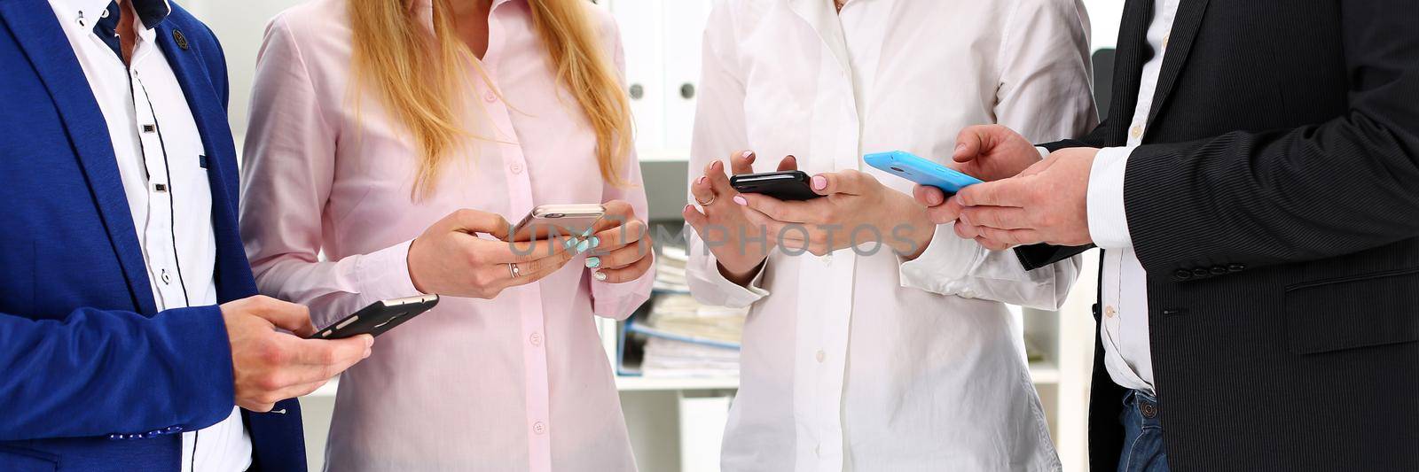 Group of people look at phones in arms at office closeup. Read news mania, send sms chat addict, use electronic bank, modern lifestyle idea, job plan colleague share, blog tweet, web search concept