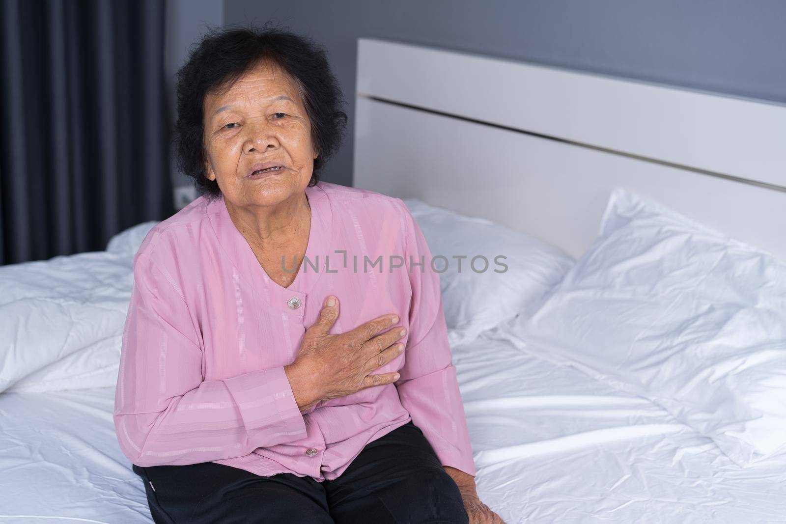senior woman having heart problem in bed  by geargodz