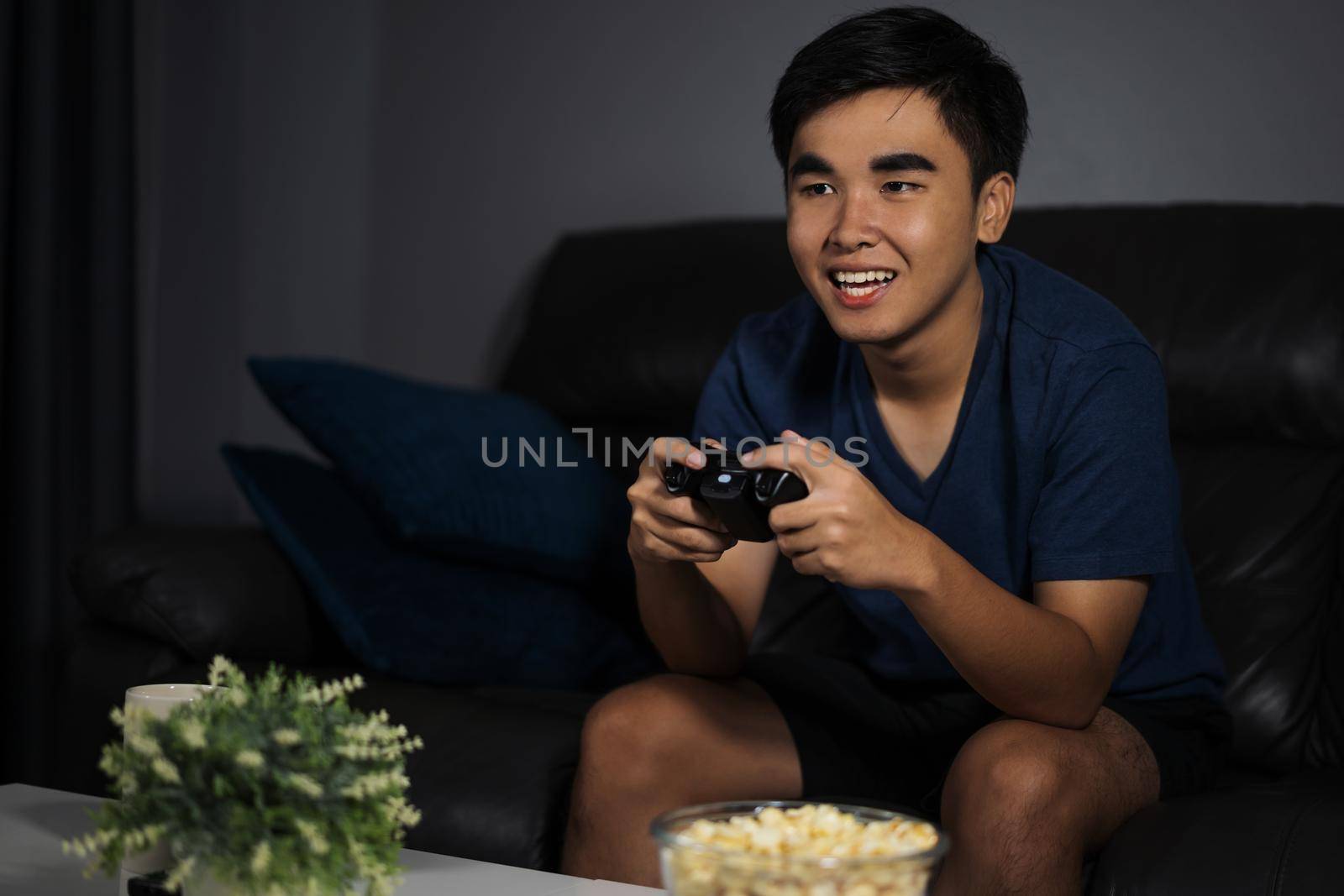 happy young man playing video games at night