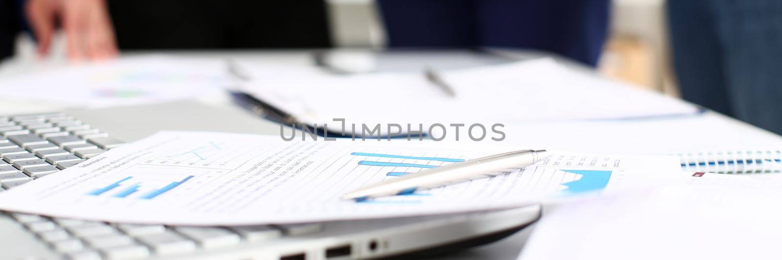 Important paper lie at table with group of colleagues in background closeup. Trade result, paperwork job, number balance, bank credit, loan money, invest payment, irs, commerce partnership concept
