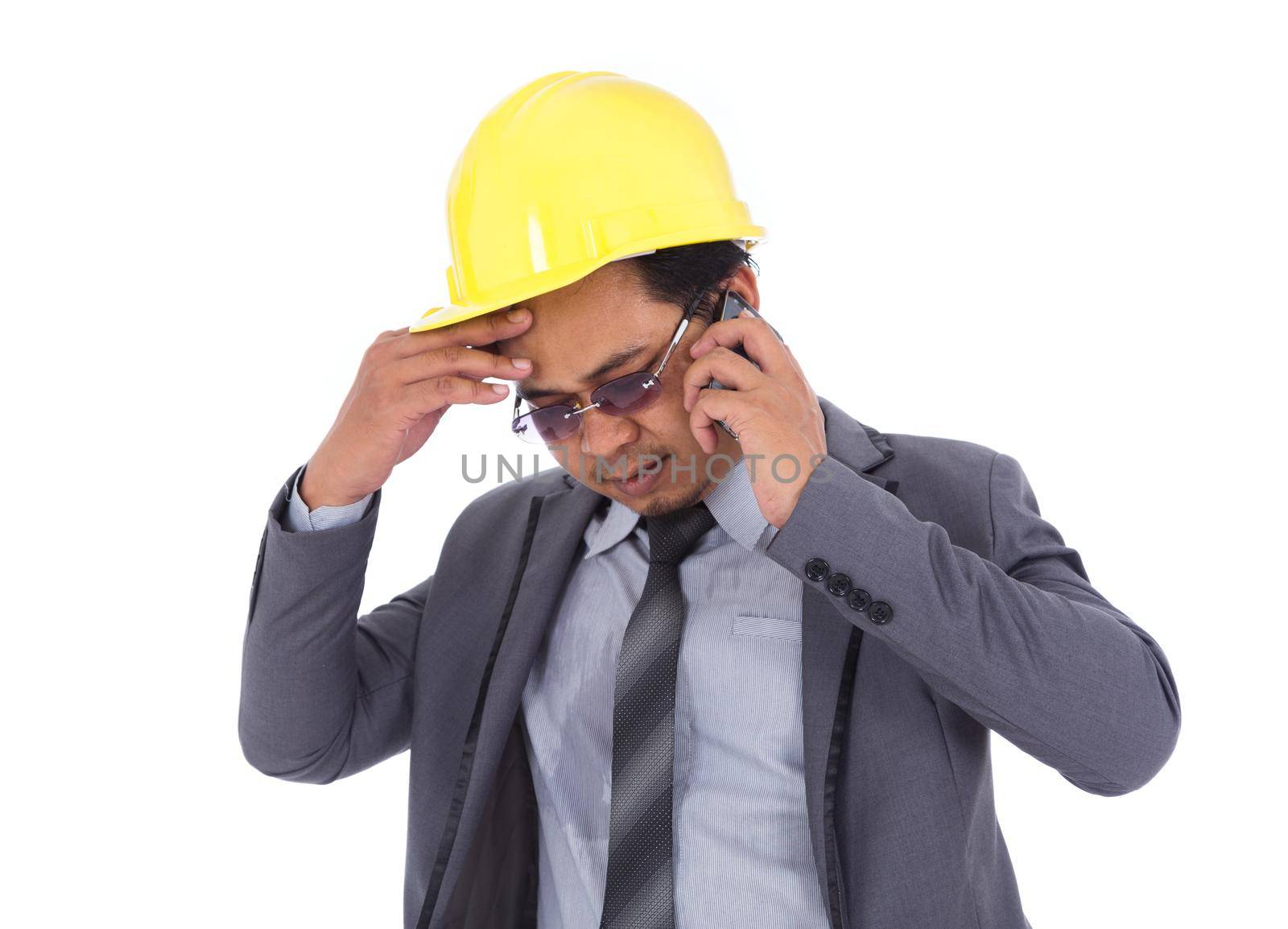 engineer receiving bad news on the cell phone isolated on a white background
