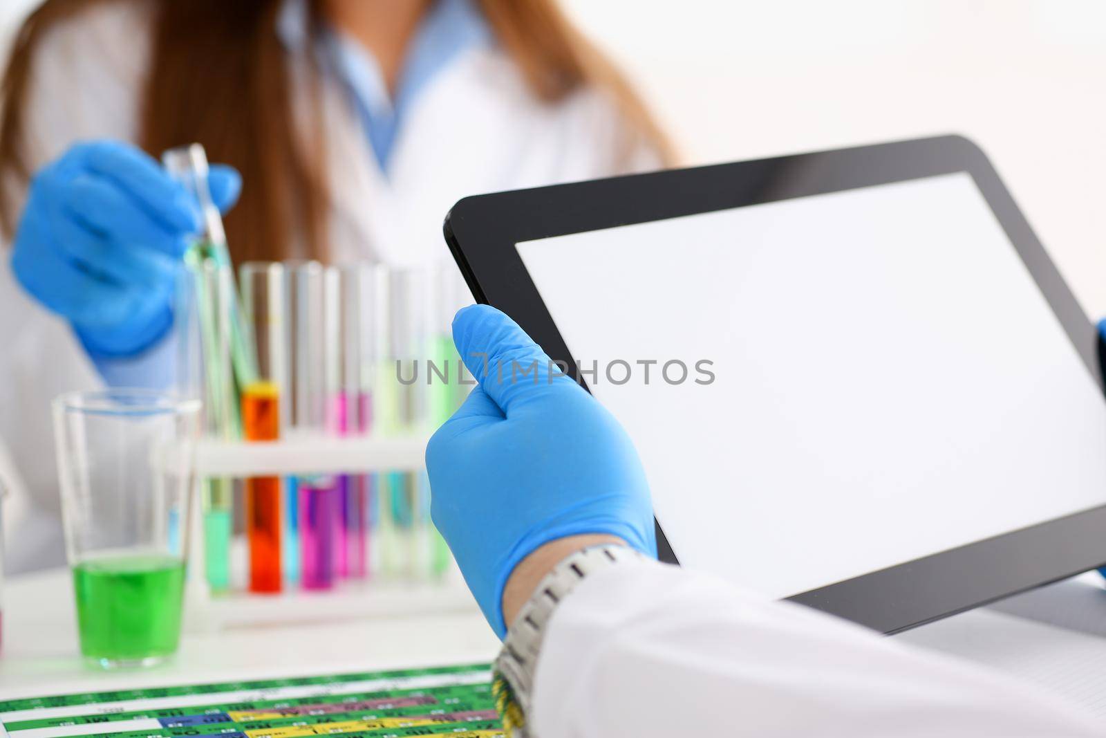 A male doctor in a chemical laboratory holds a tablet in his hand with a clean display, you can insert a picture or an image you want to write for an advertising company