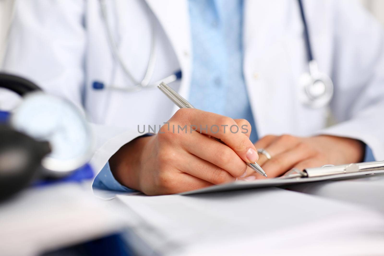 Female doctor arm hold silver pen and pad during ward round check closeup. Medic exam aid visit and remedy prescribe for sick office business visitor with problem and complaint for anamnesis concept