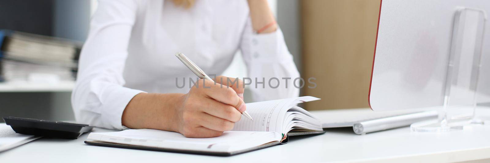 Beautiful female student hold the pen in his hand and making notes in planing letter sign
