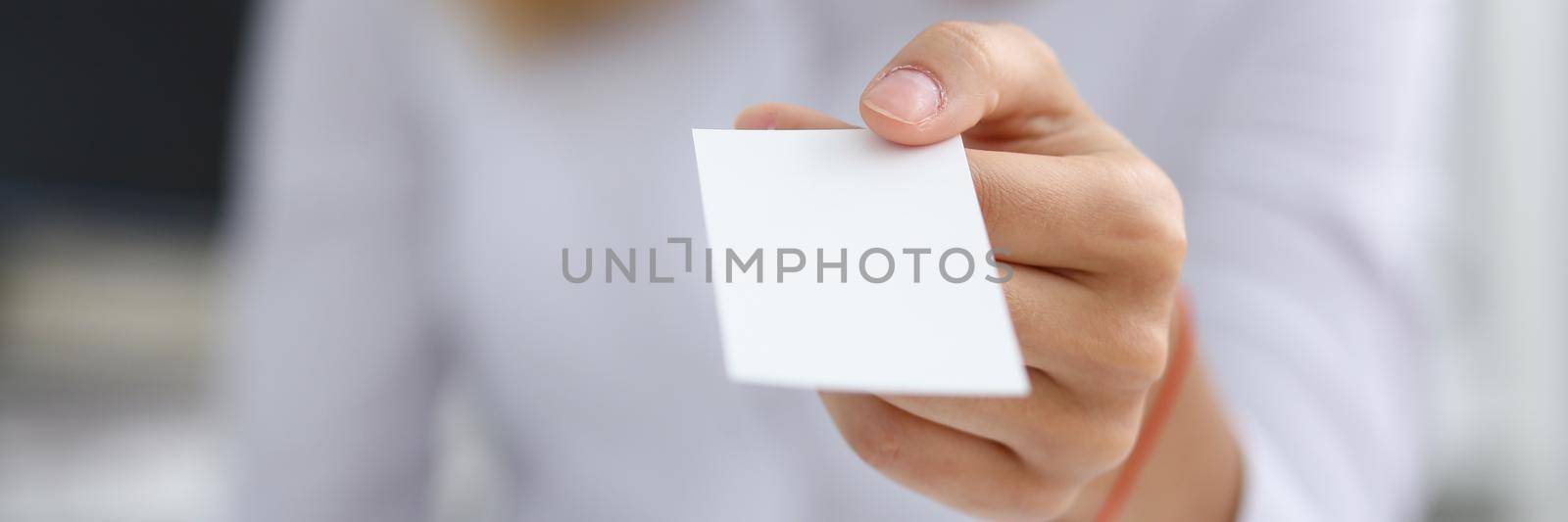 Female hand in suit give blank calling card to male visitor closeup. White collar partners company name exchange, executive or ceo introducing at conference, product consultant, sale clerk concept