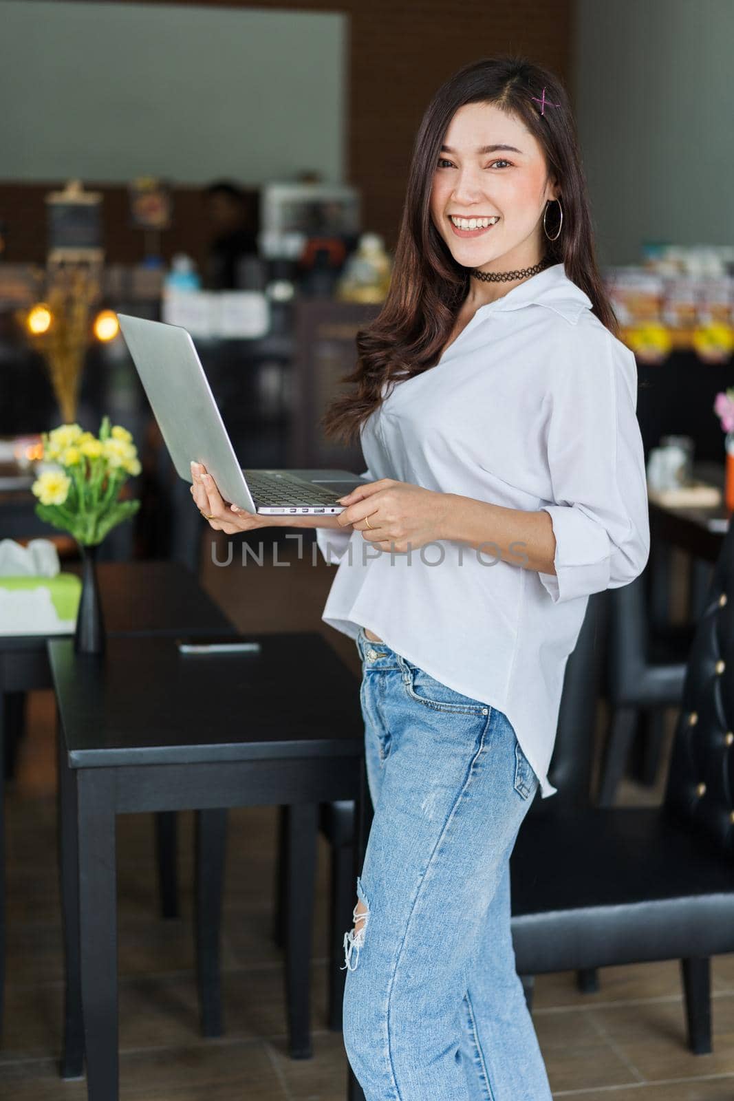 woman using laptop computer in cafe by geargodz