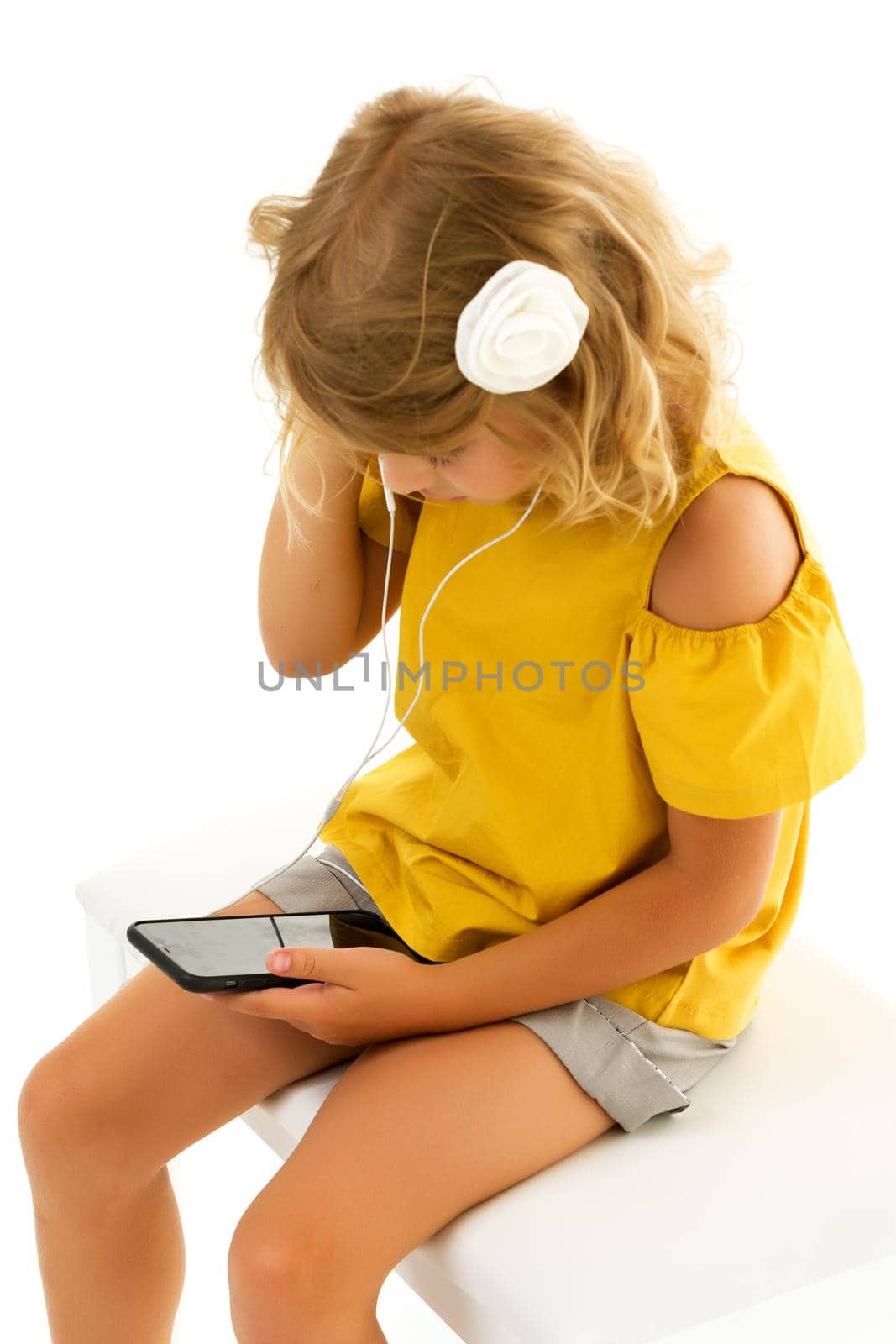 Cute little kid girl wearing headphones listening to music. Kid listening to music. Music recommended based on initial interest. The best free music apps for your mobile device. Enjoy the sound.Isolated on a white background.