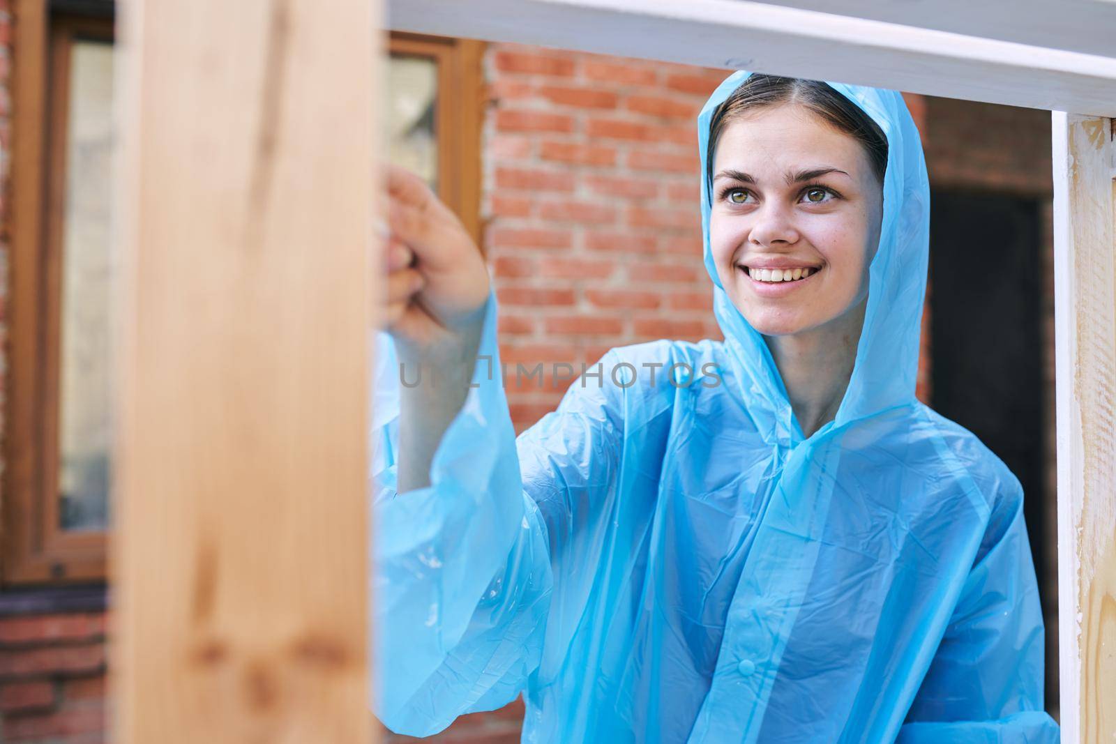 cheerful woman house painter in protective suit repairing home. High quality photo