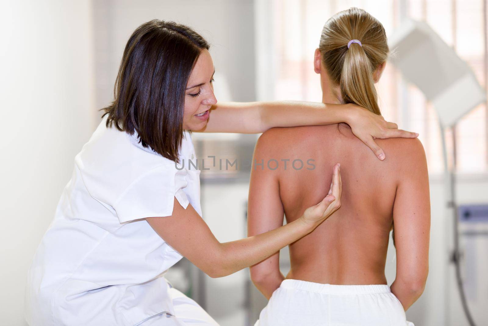 female physiotherapist inspecting her patient. Medical check at the shoulder in a physiotherapy center.