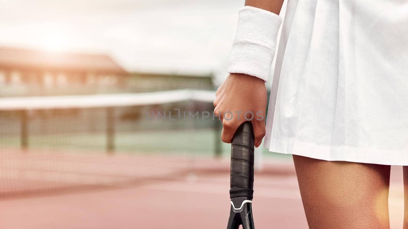 Cropped front view of legs of a sexy sporty woman on tennis court. Horizontal shot