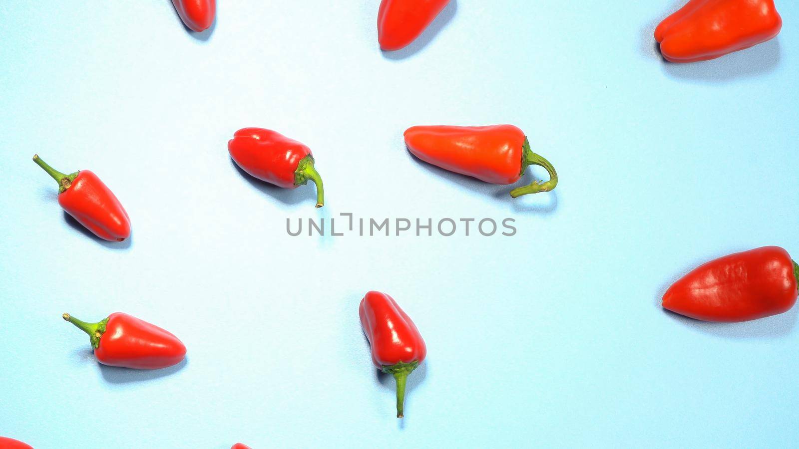 Mini red bell peppers beautifully laid out and ready to eat isolated on sky blue background. Top view.