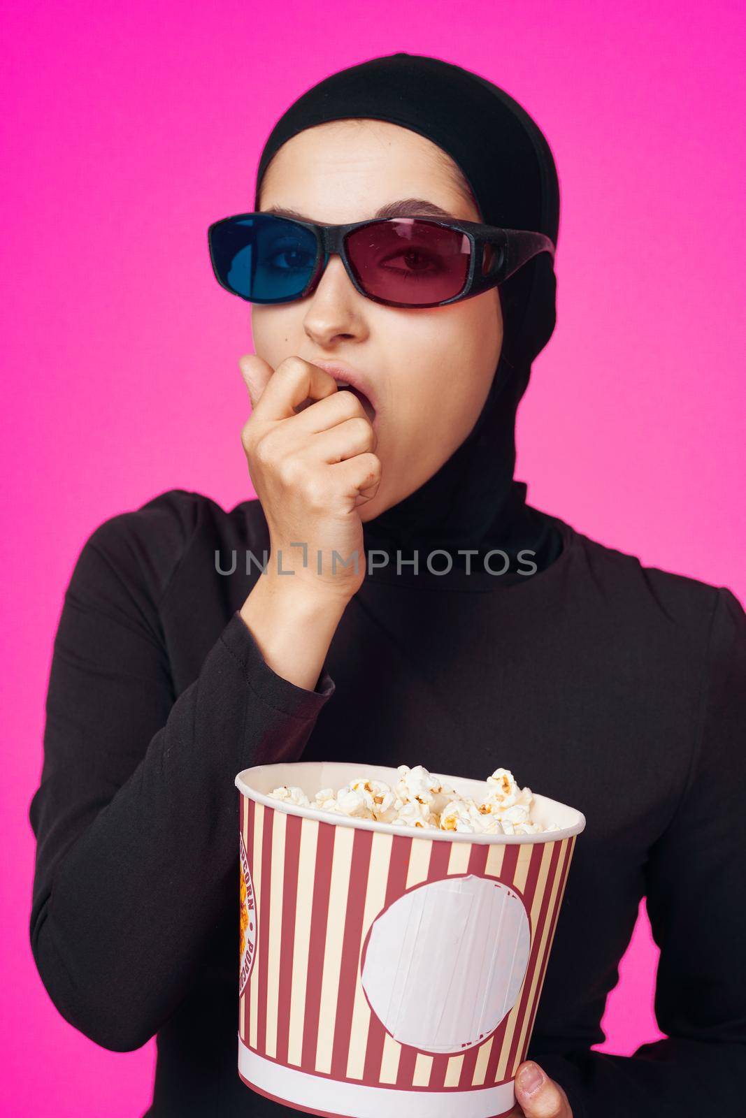 pretty woman in 3D glasses popcorn entertainment movies purple background. High quality photo