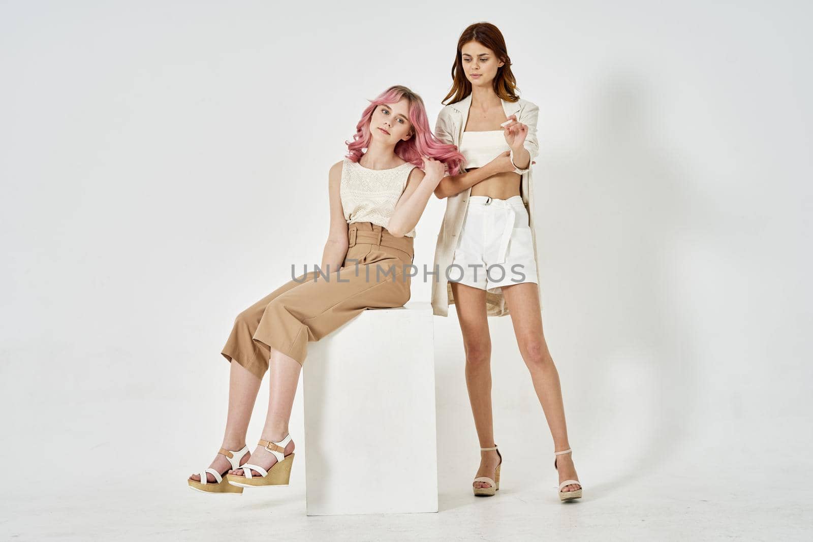 two girlfriends stand side by side posing glamor glamor luxury. High quality photo