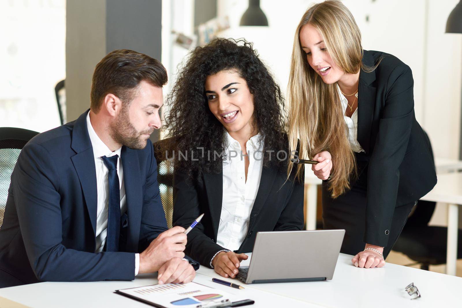 Multi-ethnic group of three businesspeople meeting in a modern office. by javiindy