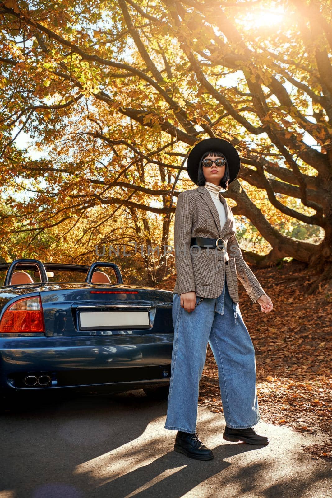 Beautiful young woman posing near cabriolet. Autumn season by friendsstock