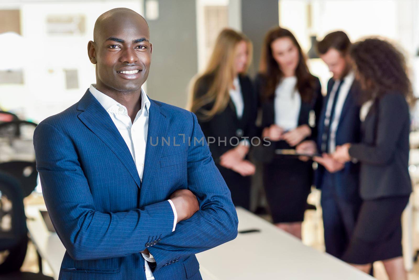 Businessman leader in modern office with businesspeople working at background by javiindy