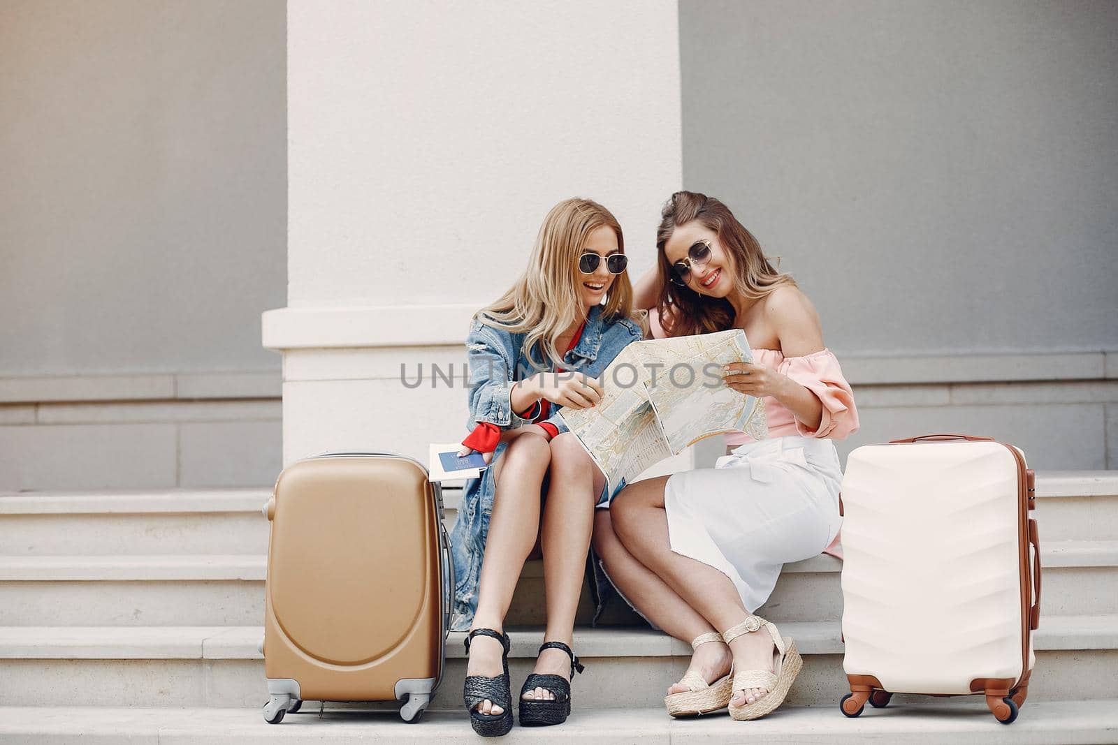 Beautiful girl in a blue jacket. Women sitting with a suitcasses