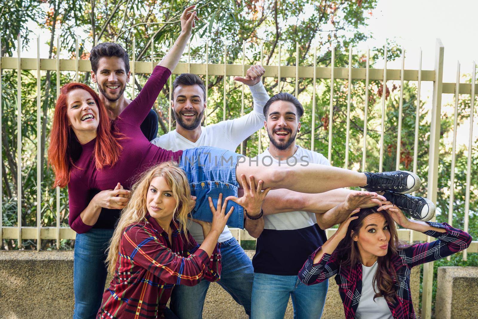 Group portrait of boys and girls with colorful fashionable clothes holding friend. Urban style people having fun - Concepts about youth and togetherness.