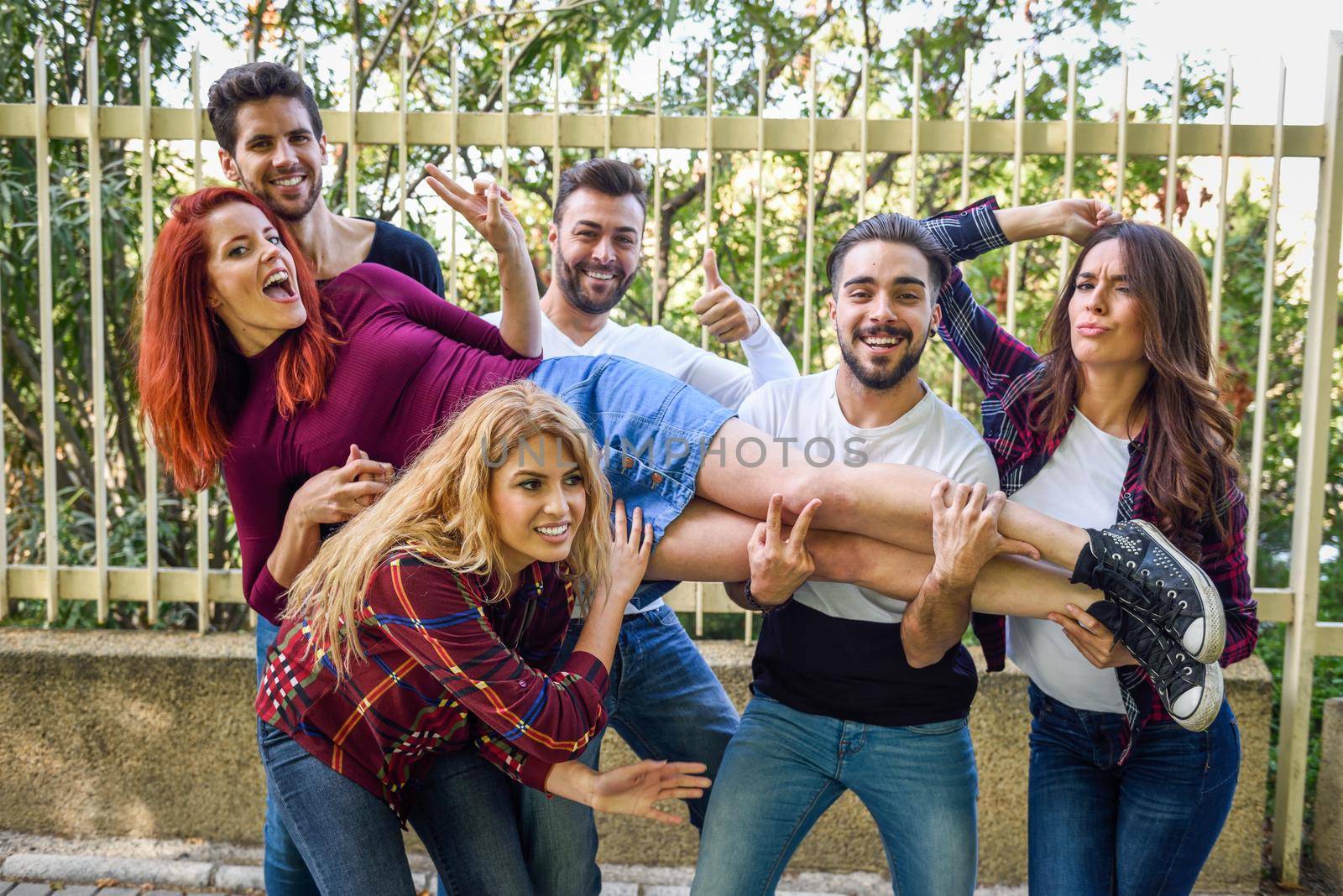 Group portrait of boys and girls with colorful fashionable clothes holding friend. Urban style people having fun - Concepts about youth and togetherness.