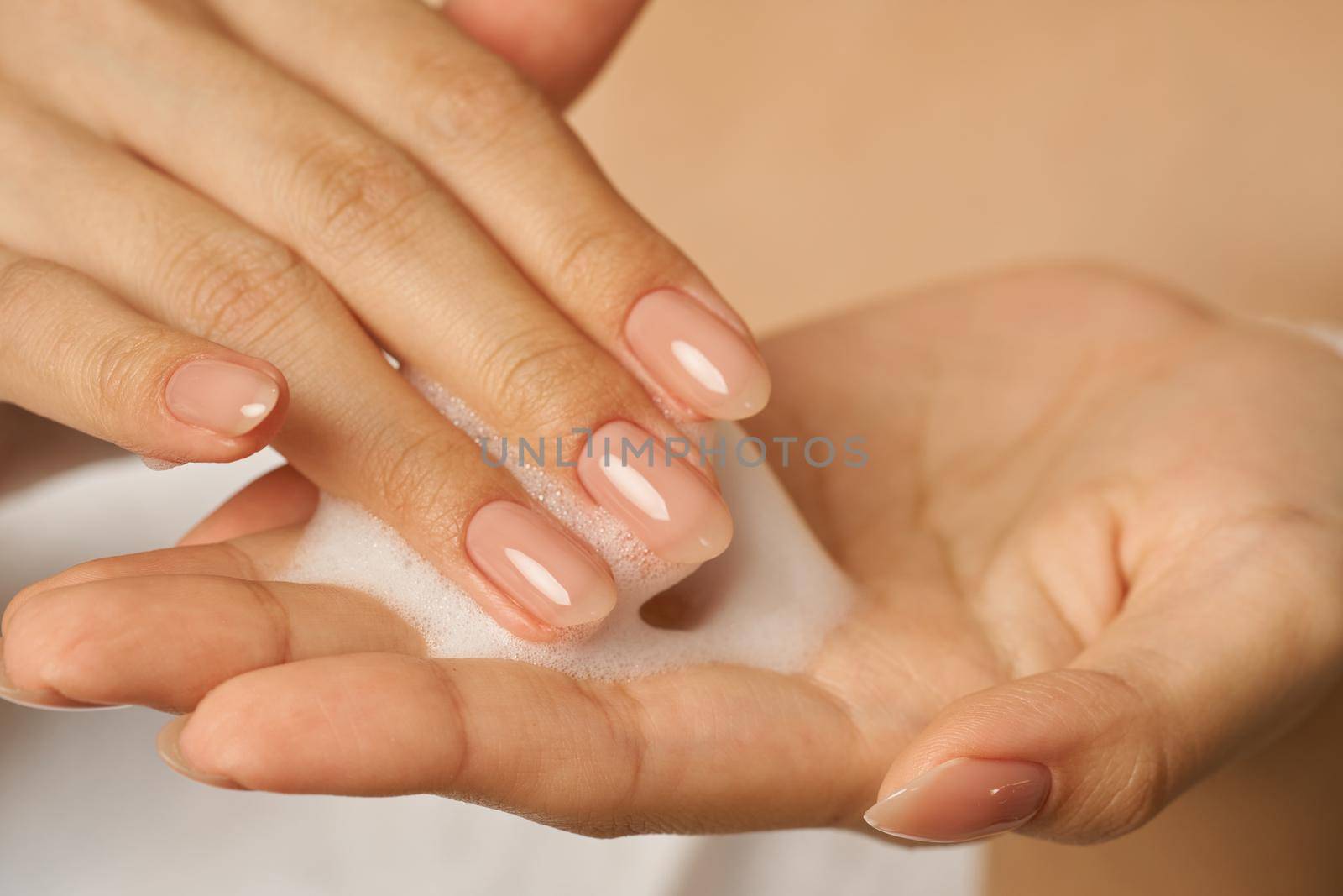 Close up of female hands holding, applying gentle foam facial cleanser by friendsstock