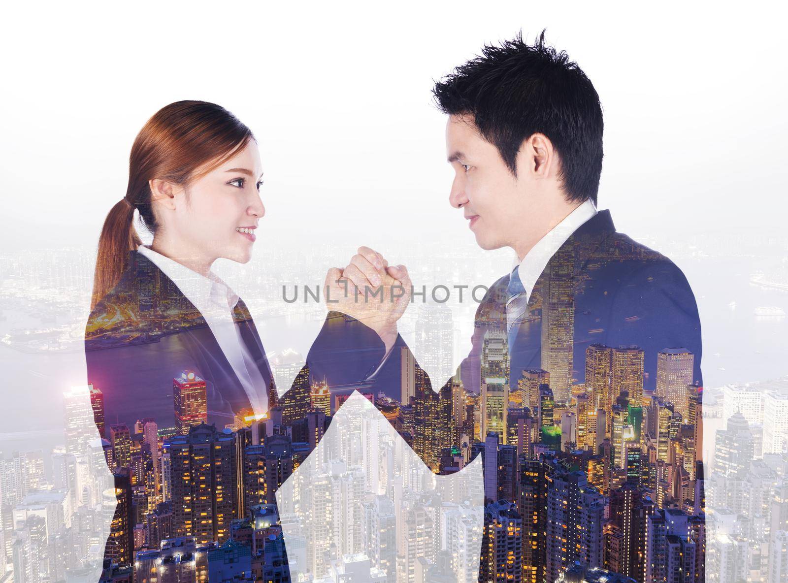 double exposure of arm wrestling between businessman and businesswoman with a city background