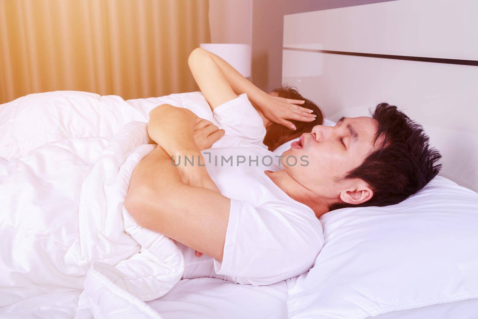 young couple have problem with man's snoring on bed