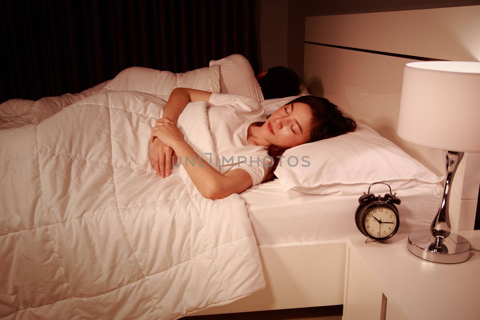couple sleeping on a comfortable bed in bedroom at night by geargodz