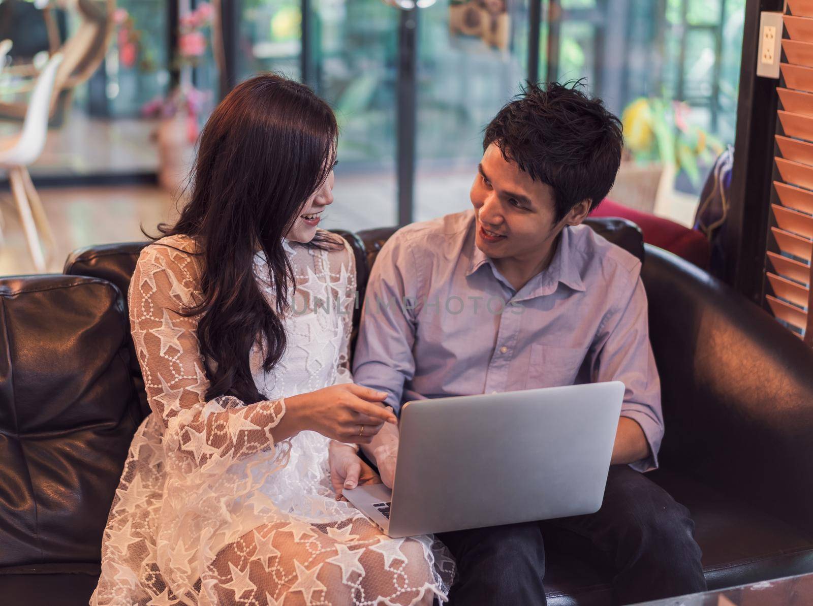 man and woman using laptop in a cafe