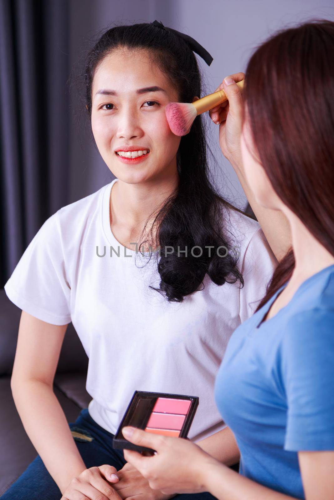 woman using brush makeup on face her friend by geargodz