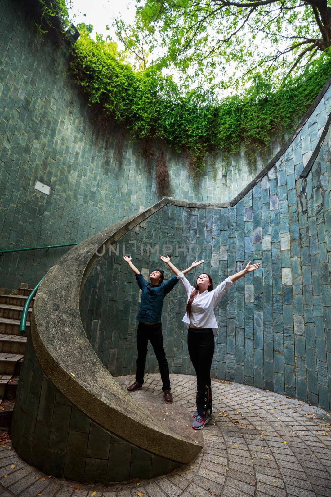 woman and man hands up at underground crossing in tunnel at Fort Canning Park, Singapore