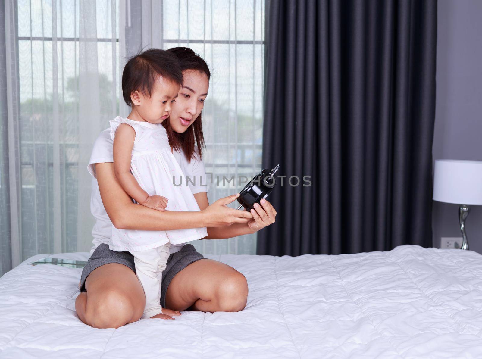 baby with mother on the bed at home