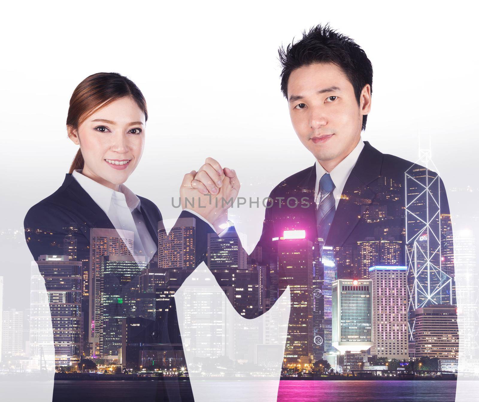 double exposure of arm wrestling between businessman and businesswoman with a city background