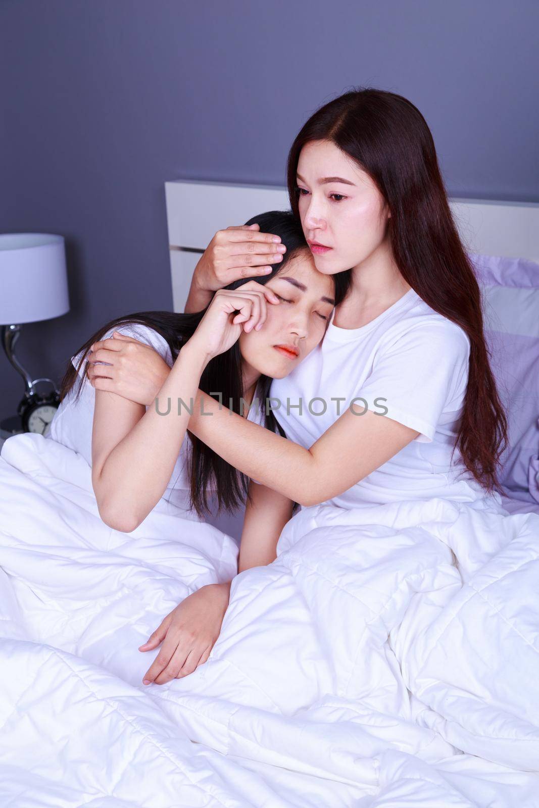 woman having problem and woman cheers her up on bed in bedroom by geargodz