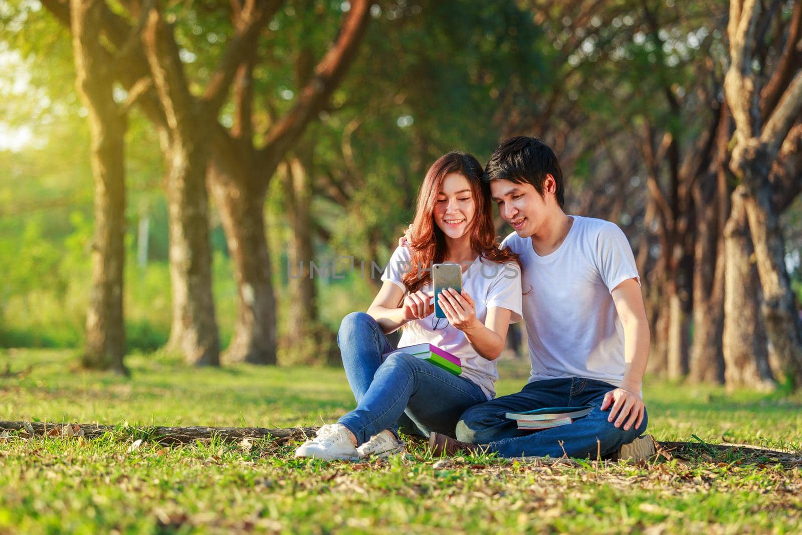 couple using mobile phone in park by geargodz