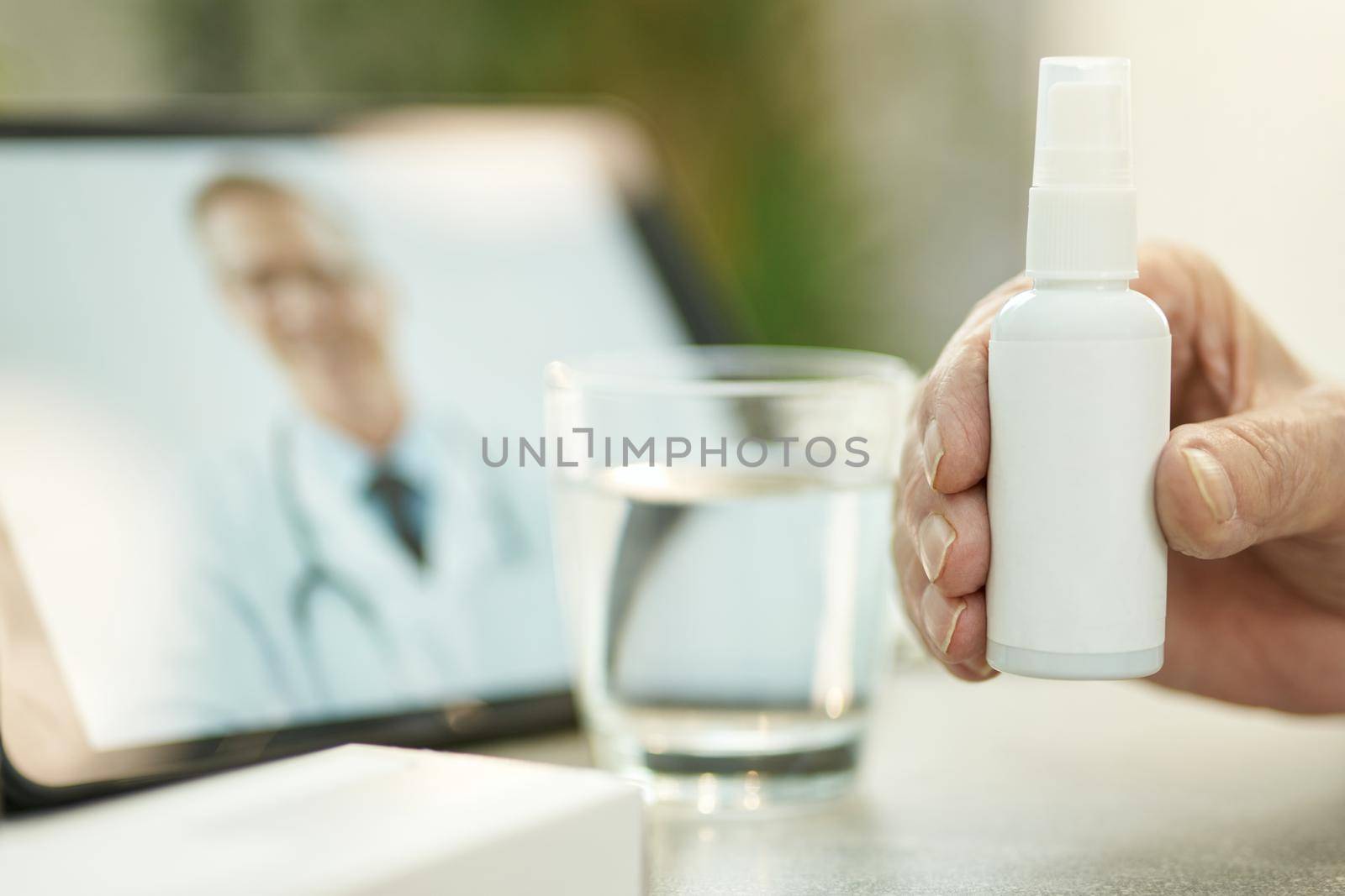 Person holding a generic spray bottle with medication by friendsstock