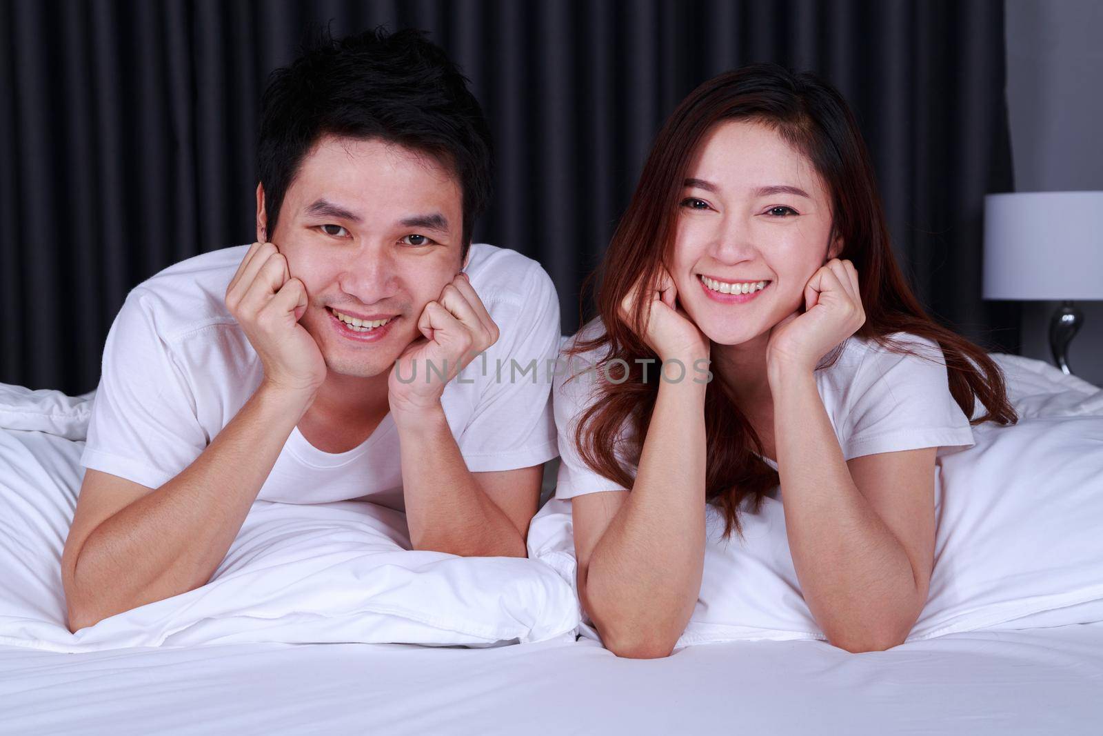 happy young couple on bed in the bedroom