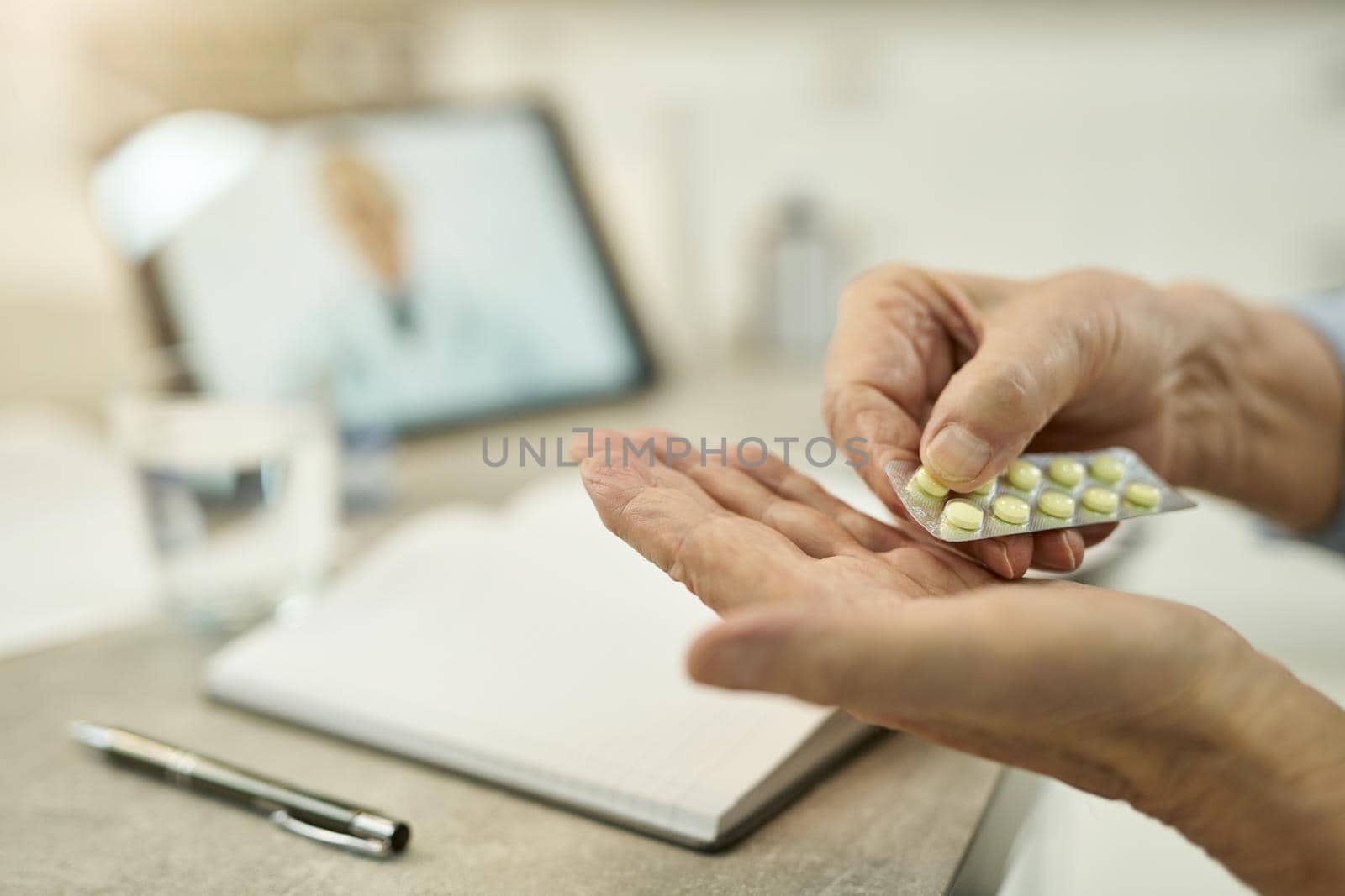 Elderly person taking medication per doctor prescription by friendsstock