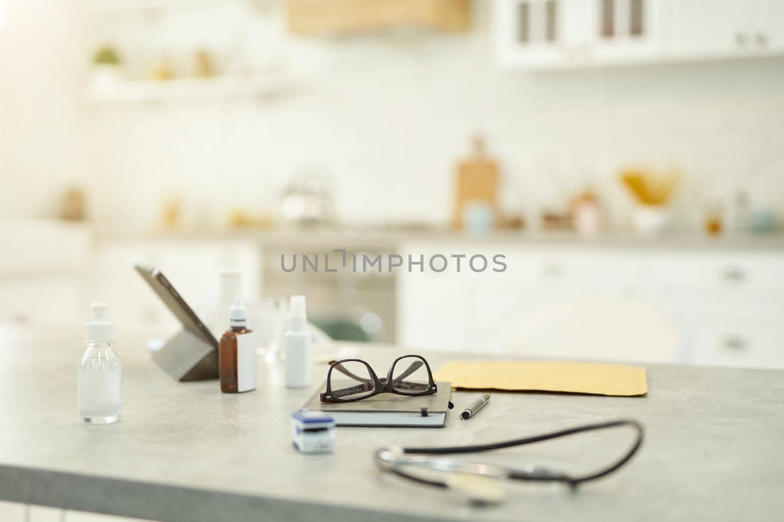 No people photo of some medication, glasses, a tablet and stethoscope sitting on the table in an apartment