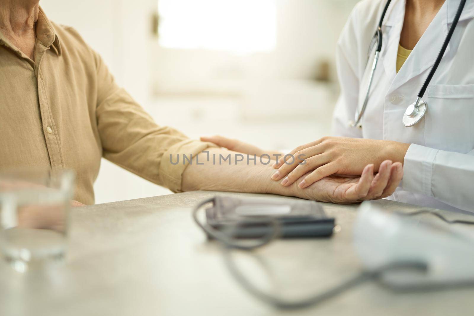 Cropped photo of medical worker in white labcoat preparing patient arm for a blood pressure checkup