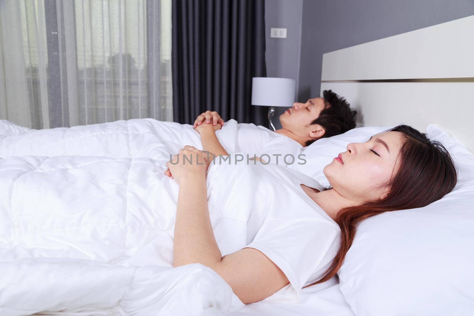 couple sleeping on a comfortable bed in bedroom at home by geargodz