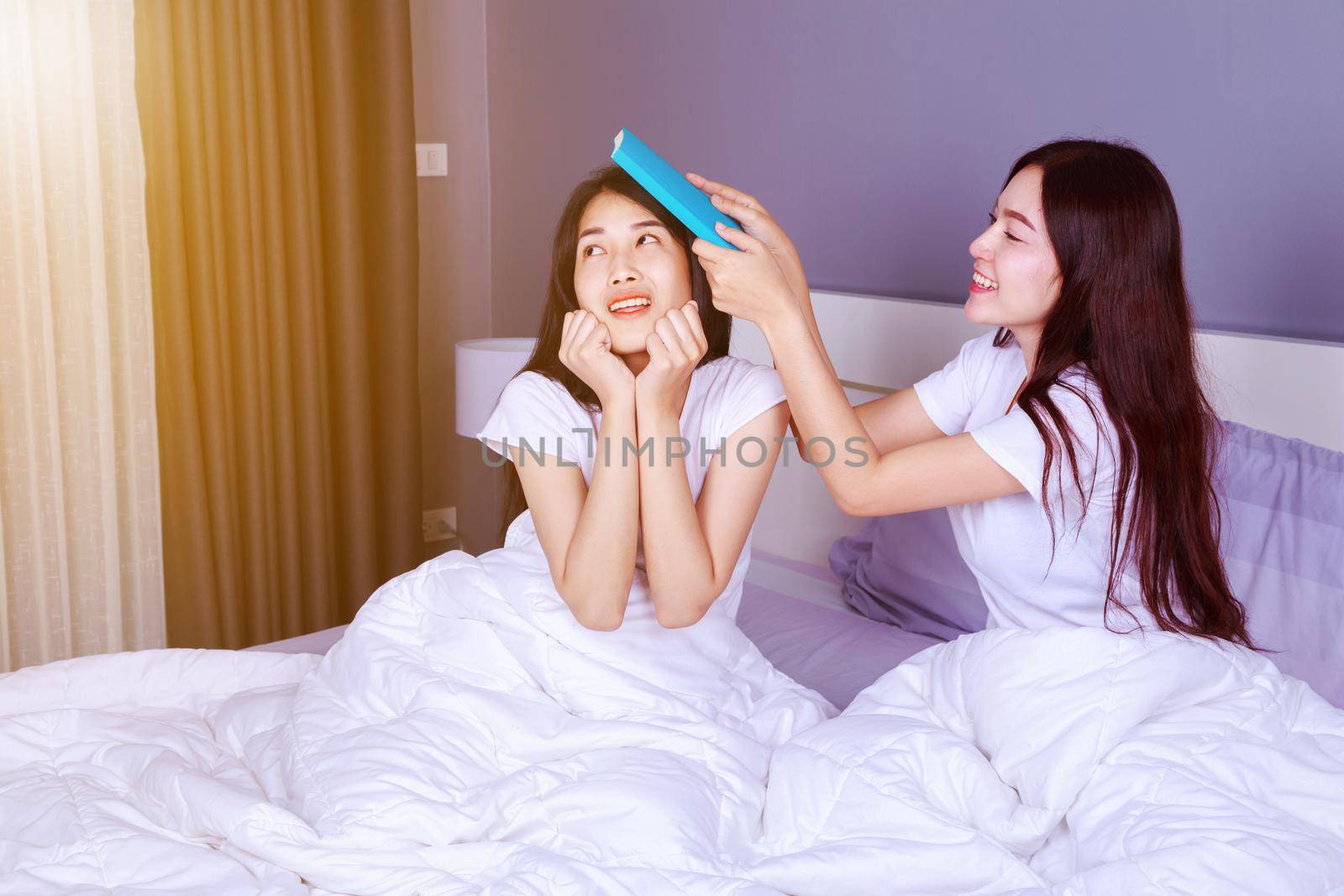 best friend woman with a book on bed in the bedroom