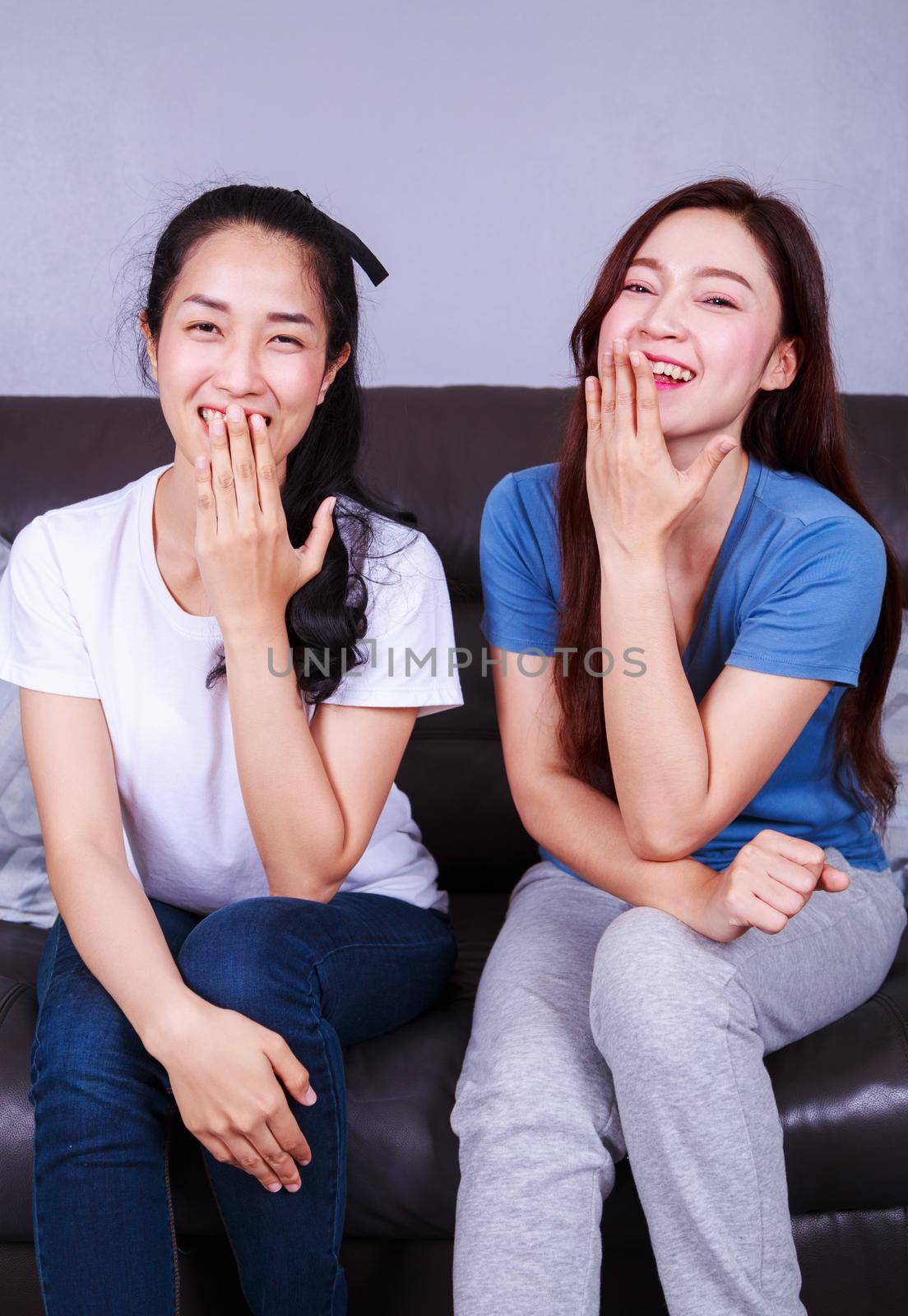 happy two woman with talking on sofa at home by geargodz