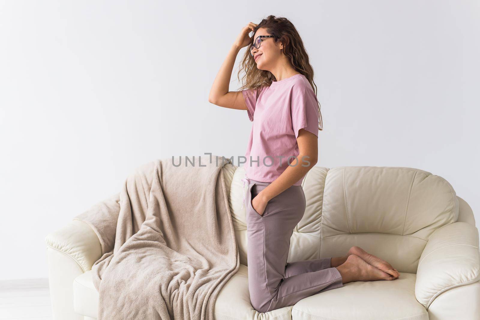 Young attractive woman dressed in beautiful colorful pajama posing as a model in her living room. Comfortable sleepwear, home relaxation and female fashion concept