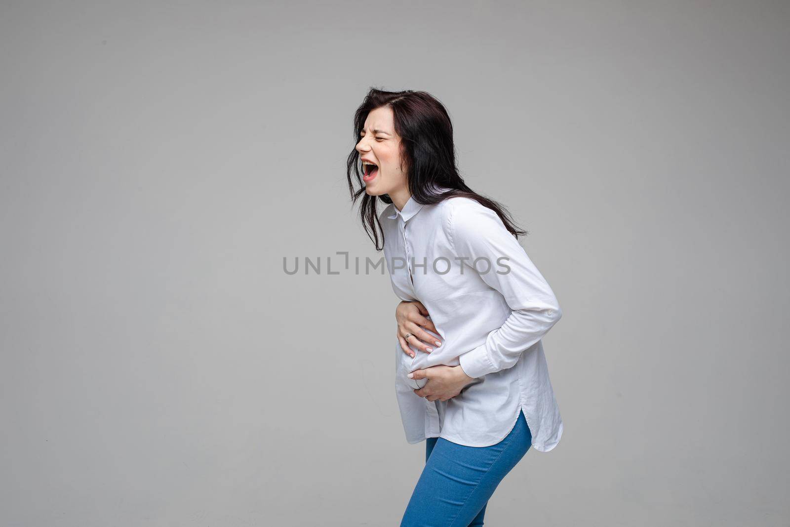 beautiful young pregnant woman screaming beacuse of a strong stomach ache by StudioLucky